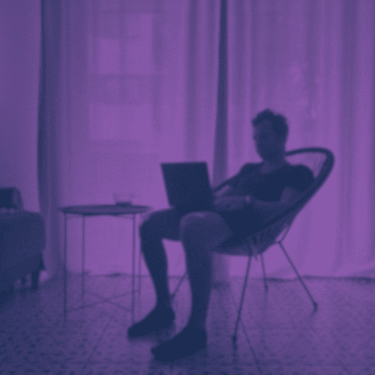 A guy sitting in a chair with a laptop